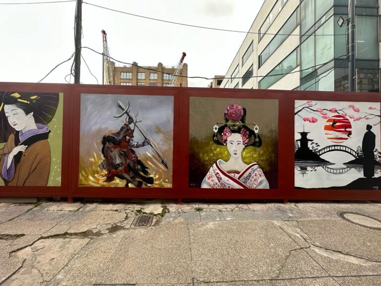 Vallado de construcción con murales artísticos en un proyecto de Juan José Pujana Mena