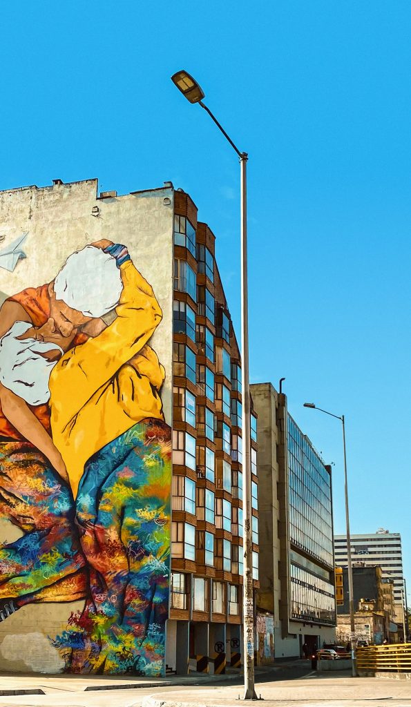Mural de una mujer con chaqueta amarilla en Bogotá